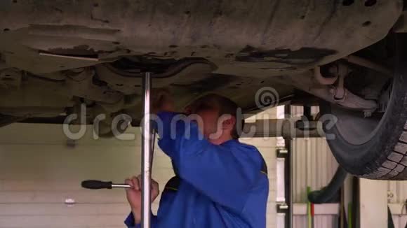 汽车修理工在蓝色的过度修理汽车电梯在车库视频的预览图