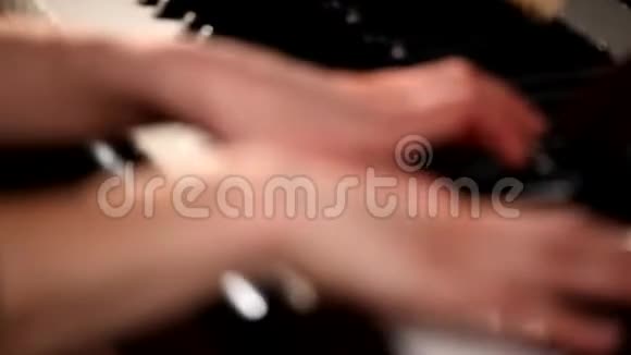 两只手在一架漂亮的大钢琴上演奏视频的预览图