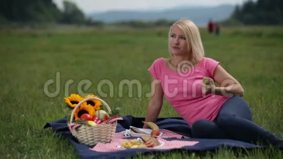 野餐的女人吃苹果视频的预览图