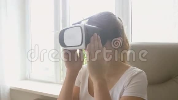 兴奋的年轻女子坐在椅子上使用VR耳机的肖像4K拍摄的录像视频的预览图