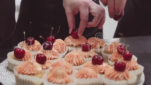 甜点手装饰松饼奶油顶部与樱桃浆果视频的预览图