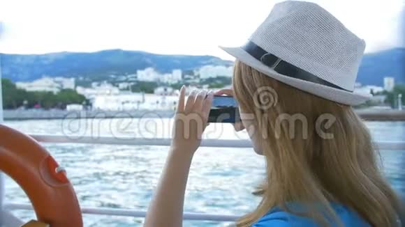 戴帽子的女人用游艇做自拍海湾背景是克里梅镇视频的预览图