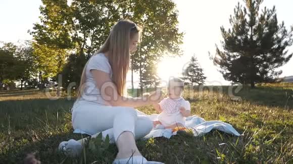 在耀斑日落时母亲缓慢地喂女儿吃蔬菜视频的预览图