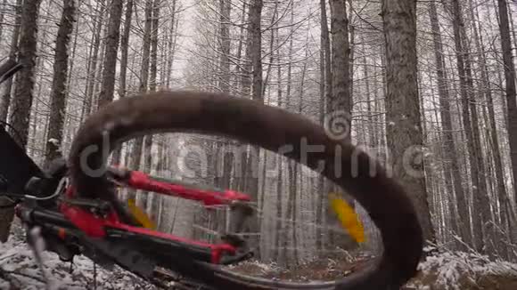 冬天木头里的自行车躺在一边自行车轮在地球上转动冬木里的红色自行车视频的预览图