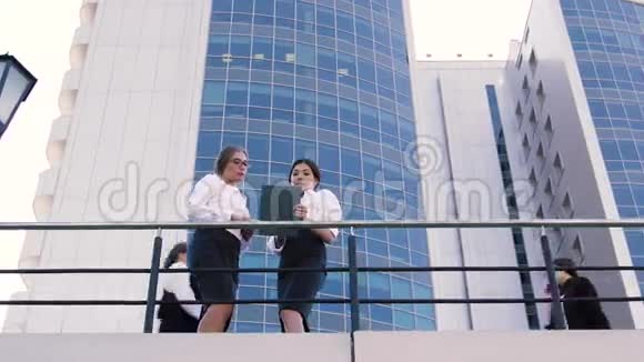 漂亮的商务男士来到办公楼的露台上两位漂亮的商务女士正在聊天视频的预览图