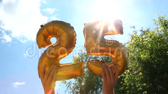 25岁生日快乐双手拿着数字气球视频的预览图