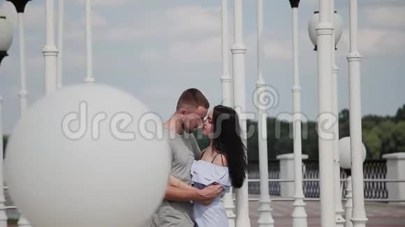 一对相爱的夫妇在路灯附近的堤岸上拥抱和亲吻视频的预览图