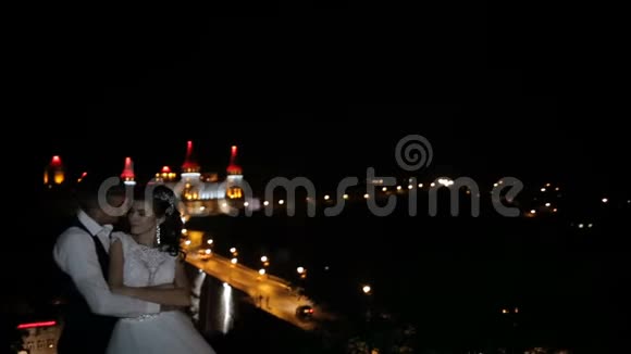 山上美丽的城堡夜晚岩石上的强化宫殿带有红色蓝色背光的毛巾两个人视频的预览图