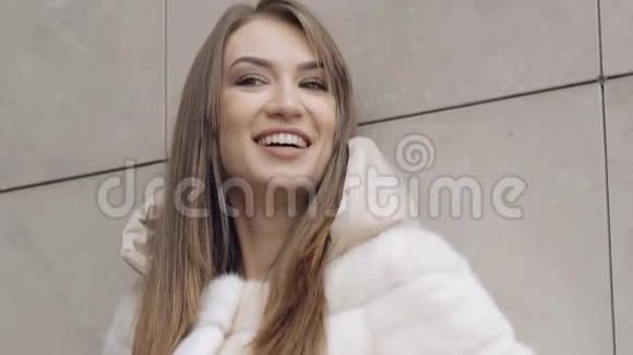 热情的女人穿着毛茸茸的外套在镜头前微笑慢慢地视频的预览图
