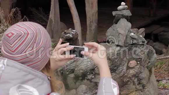 年轻的女游客在她的智能手机上为古老的村庄拍照视频的预览图