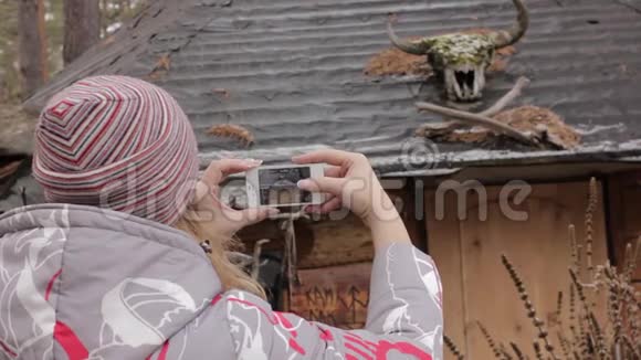 年轻的女游客在她的智能手机上为古老的村庄拍照视频的预览图