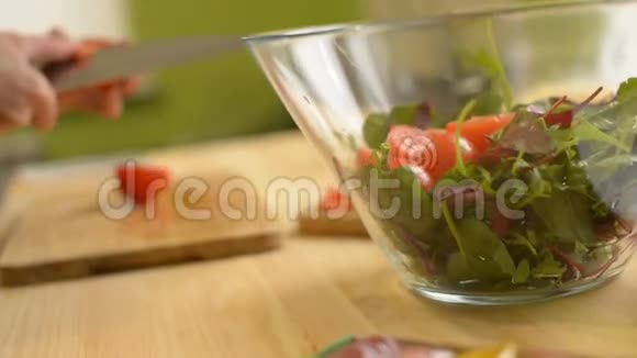 一个女孩的特写镜头切一张番茄木桌用来做绿色番茄柠檬和奶酪沙拉视频的预览图
