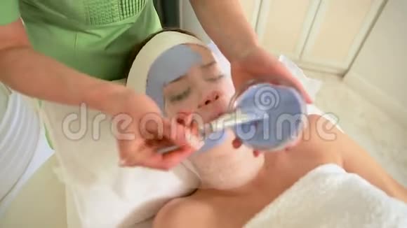 年轻漂亮的女人戴着蓝色面具水疗治疗视频的预览图