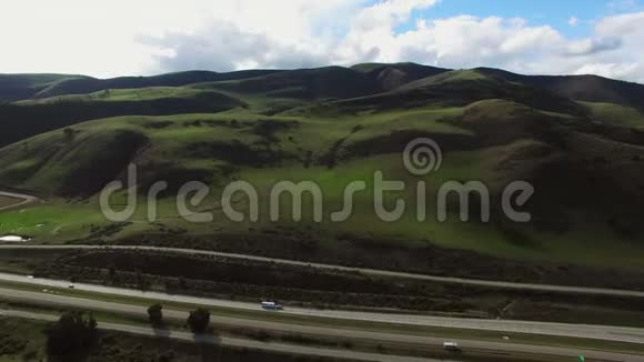 高速公路和大片绿色田野和丘陵的空中拍摄视频的预览图