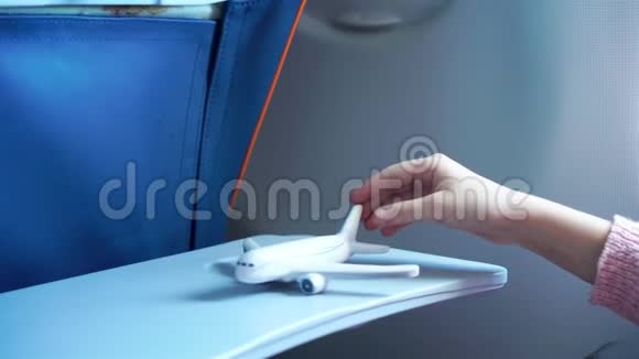 特写手举着飞机模型玩具背景窗在飞机内部视频的预览图