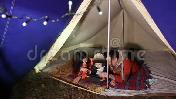 快乐的家庭与平板电脑和帐篷在营地视频的预览图