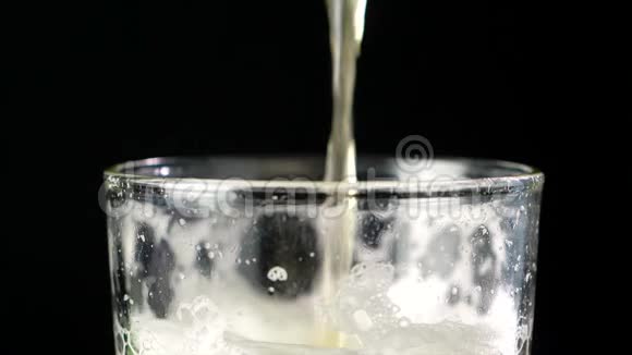 缓慢运动的啤酒倒入玻璃中在黑暗的背景下有气泡视频的预览图