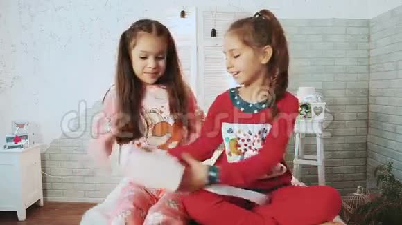 穿着睡衣的小孩坐着他们互相赠送礼物视频的预览图