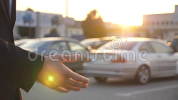 商人的手臂在日落时通过汽车钥匙男性手把车钥匙给他的朋友两个企业之间的握手视频的预览图
