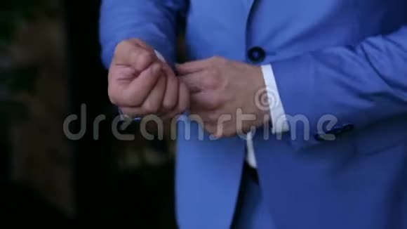 成功的男人穿着蓝色西装挺直袖子特写视频的预览图