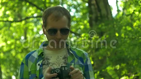 摄影师设置摄像头穿格子衬衫的年轻人视频的预览图
