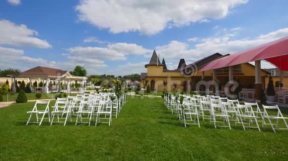 结婚通道装饰白色结婚椅户外婚礼婚礼设在花园里晴天视频的预览图
