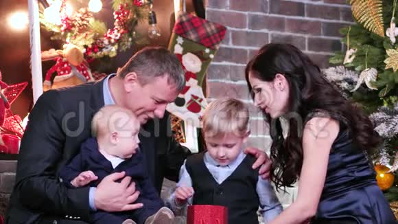 父母和孩子在一起父母和儿子看圣诞礼物家人庆祝新年视频的预览图
