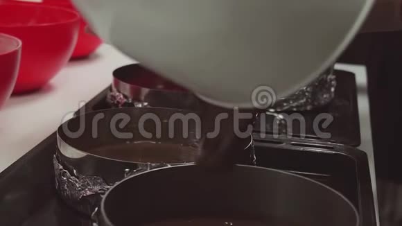 女人的手把巧克力面团洒在厨房的烤盘里视频的预览图