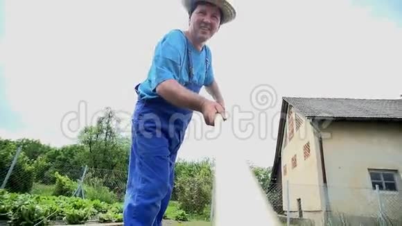 园丁从耙的角度耙花园里的土壤视频的预览图