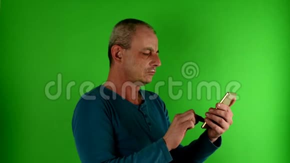 成熟的中年男人在打电话一个成熟的白人在绿色屏幕前发短信的肖像视频的预览图