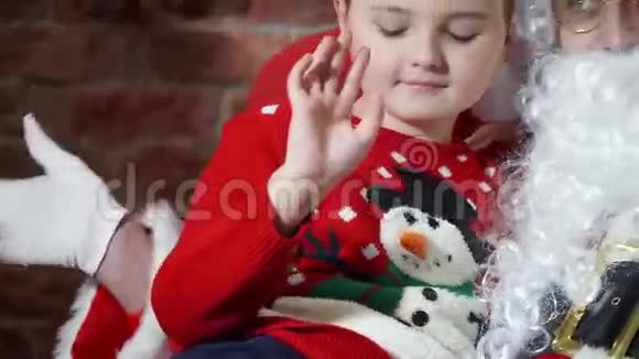 一个男孩的特写镜头圣诞老人和女孩挥手视频的预览图
