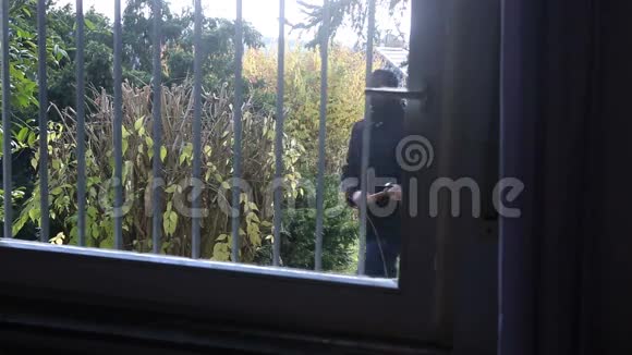 带面具的窃贼试图进入窗户视频的预览图