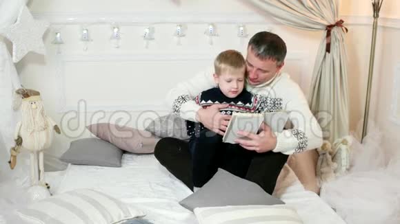 一个慈爱的父亲读一本书给他的儿子而花时间在一起家人读一本书一个孩子视频的预览图