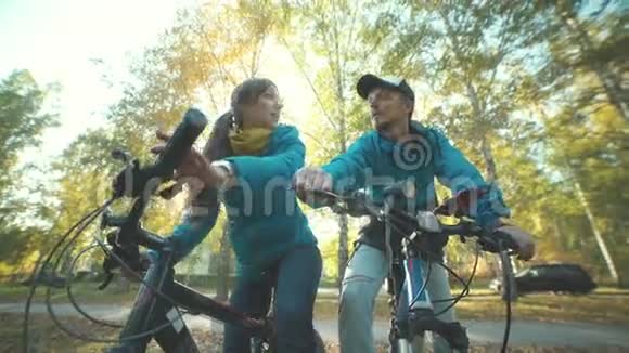 男人和女孩在秋树骑行的背景下视频的预览图