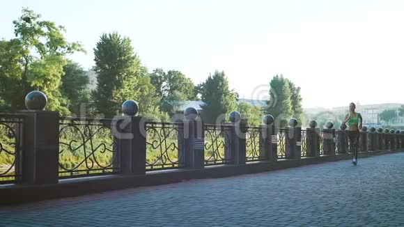 活跃的妇女慢跑在阳光明媚的城市公园慢动作视频的预览图