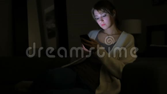 疲惫的女人晚上使用智能手机视频的预览图