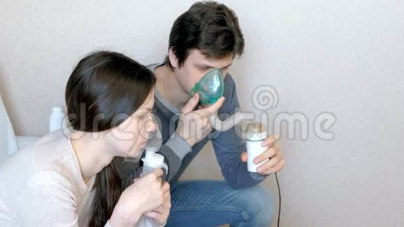 使用雾化器和吸入器进行治疗男人和女人通过吸入器面罩吸入侧视视频的预览图