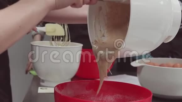 女人的手把奶油面团放到厨房的烤盘里视频的预览图