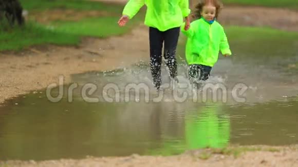 快乐女孩和男孩在巨大的水坑中快乐视频的预览图