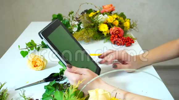 用平板电脑拍摄女性花店的近照该平板电脑可以搜索有关花的信息并写出t视频的预览图