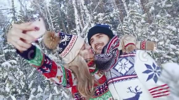 微笑的夫妇在冬天的森林里拍照视频的预览图