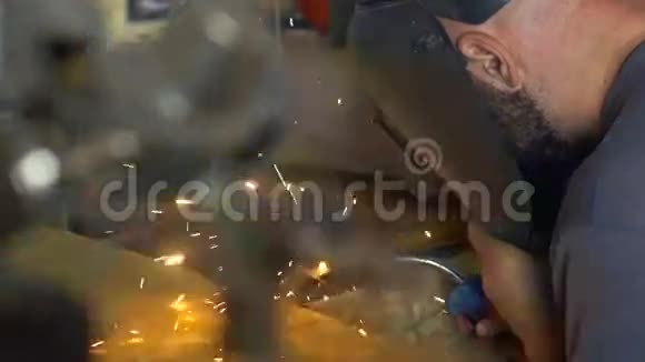 戴防护面罩的人在车库焊接金属视频的预览图
