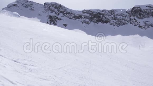 晴天的山景滑雪胜地斜坡上的滑雪板蓝天视频的预览图