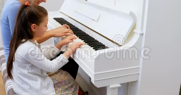 母亲协助女儿弹钢琴视频的预览图