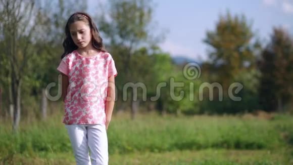 美丽悲伤的小女孩站在大自然上视频的预览图