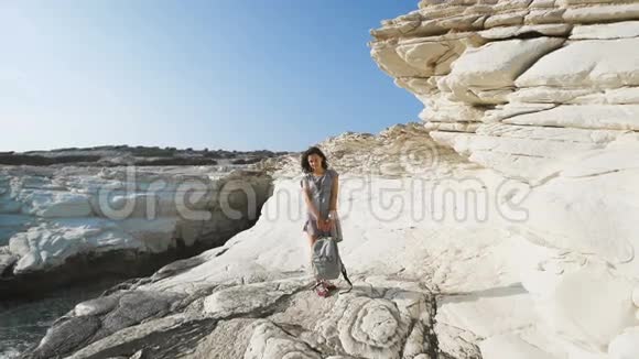 一位年轻女子穿着一件长t恤站在海边视频的预览图