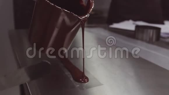 从塑料条上的量杯中融化的巧克力溢出视频的预览图