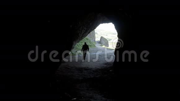 一个人走进黑暗洞穴的轮廓视频的预览图