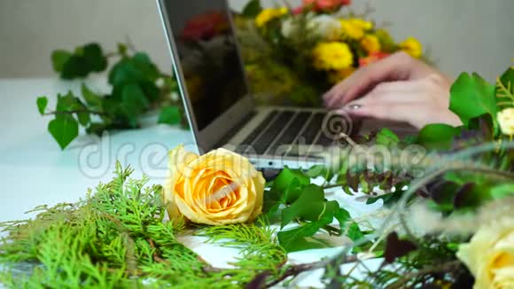 电脑和花姑娘的手在桌子上的小玩意键盘上印着办公室里的植物的特写镜头视频的预览图