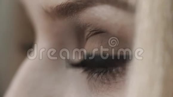 年轻女子灰色的眼睛眨着黑色睫毛膏和眼线视频的预览图